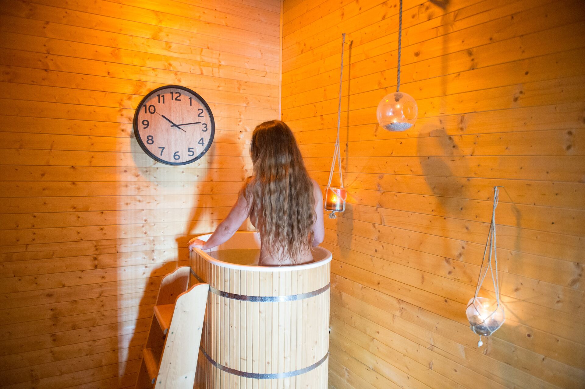 Klientka v drevenej ochladzovacej kadi ZEN SPA — kontrast po saune